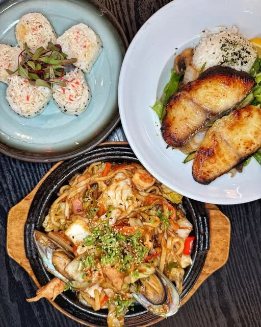 Grilled fish with rice alongside noodles and sushi rolls at Starfish
