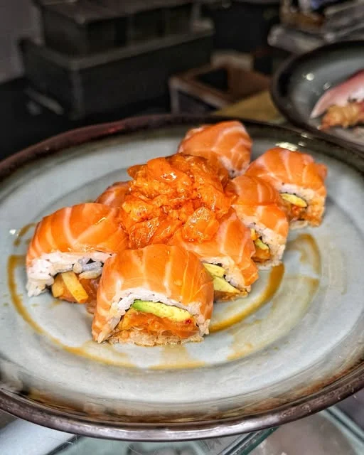 Salmon-topped rolls with avocado on a ceramic plate at Starfish